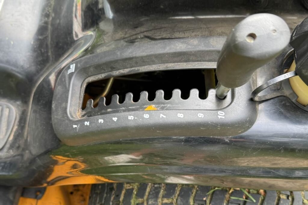 Mower deck height lever set to its highest position for mulching leaves